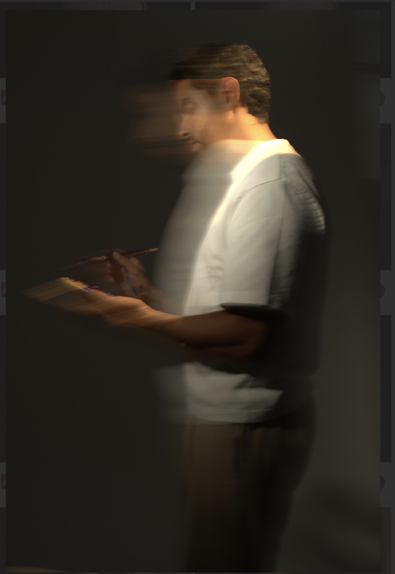 Anwar Rouane painting in low light, motion-blurred, holding brush and palette.
